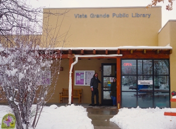 entrance to Vista Grande Public Library, NM, with figures in the doorway and snow on the ground